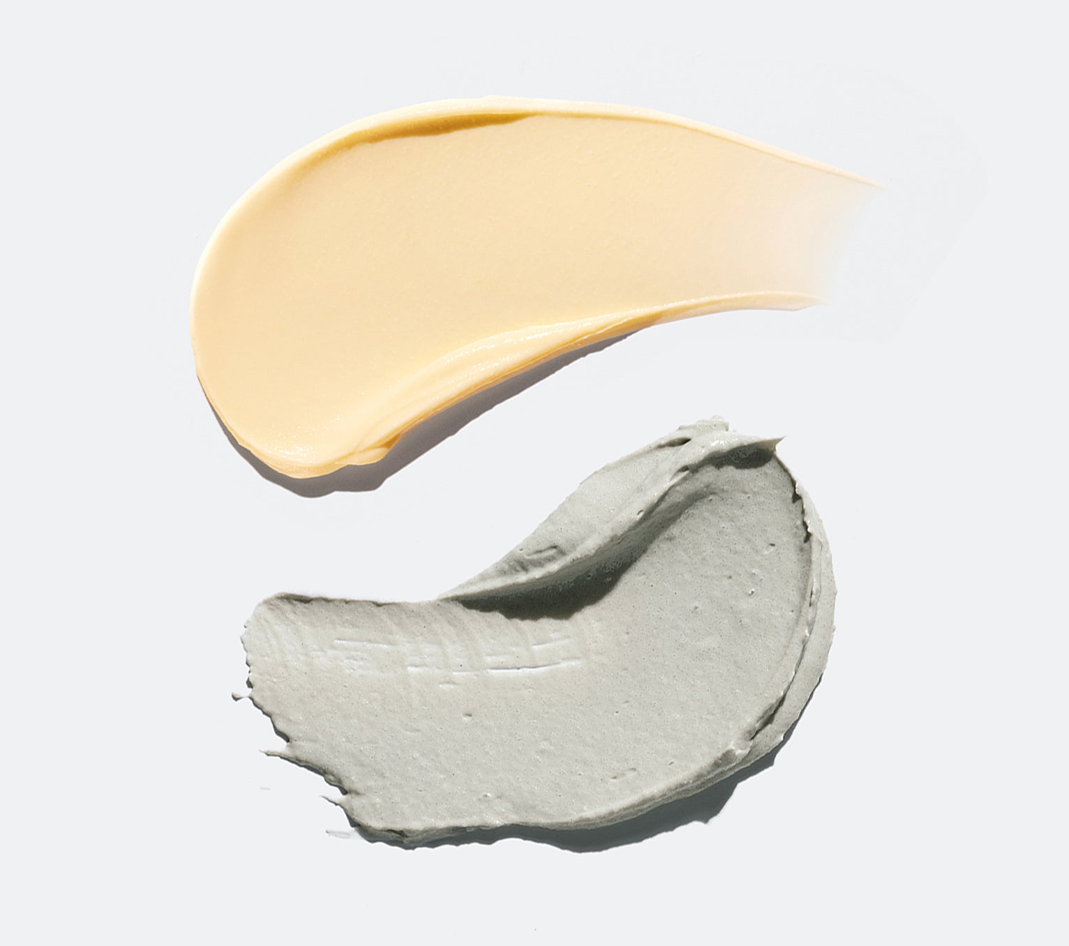 Swipe of a light-yellow cream and light-green scrub.