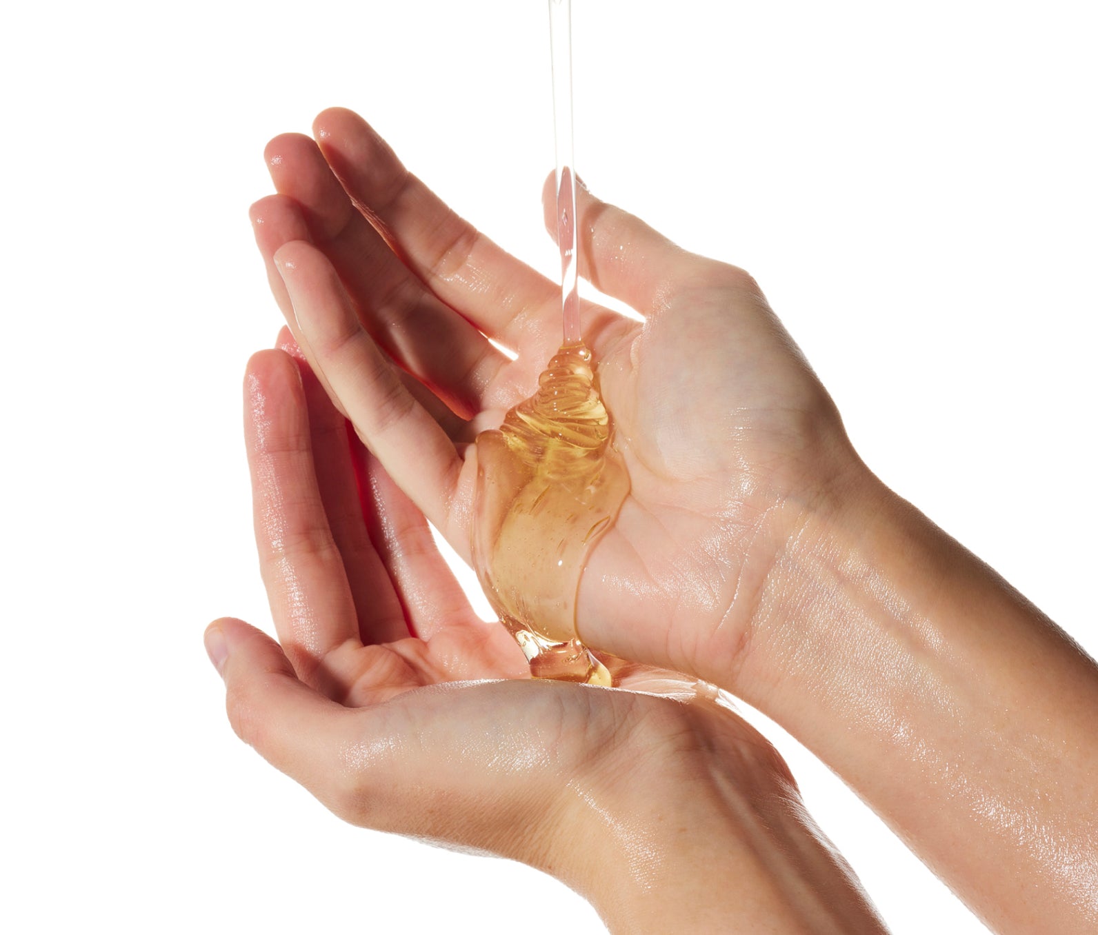 Ursa Major Botanic Buzz Hand Wash pouring onto two hands on a white background.